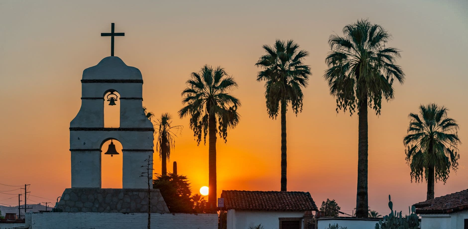 Captivating sunset behind a historical church and palm trees in Redlands, CA.
