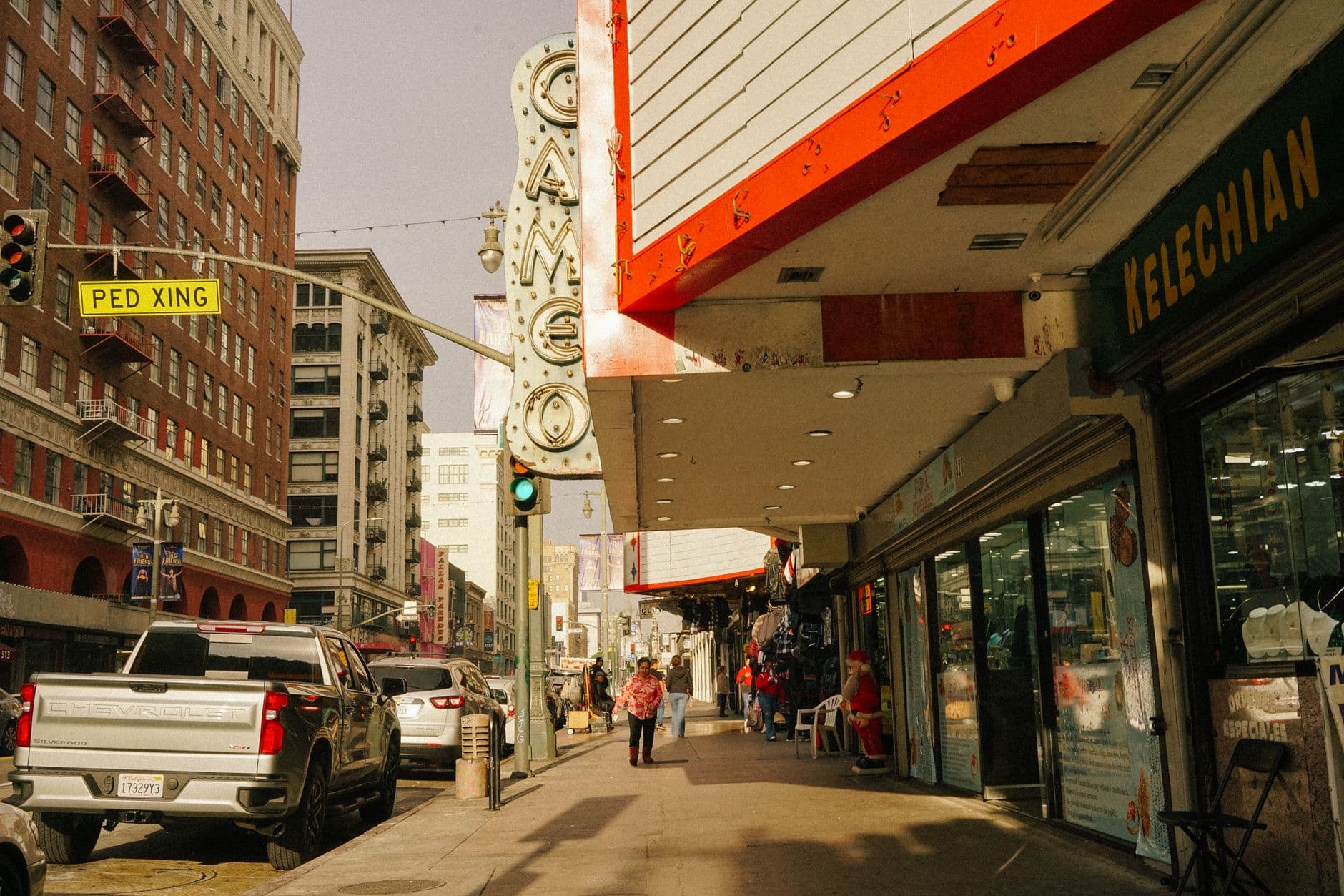Urban street scene featuring Cameo Theater and pedestrians in a bustling downtown area.