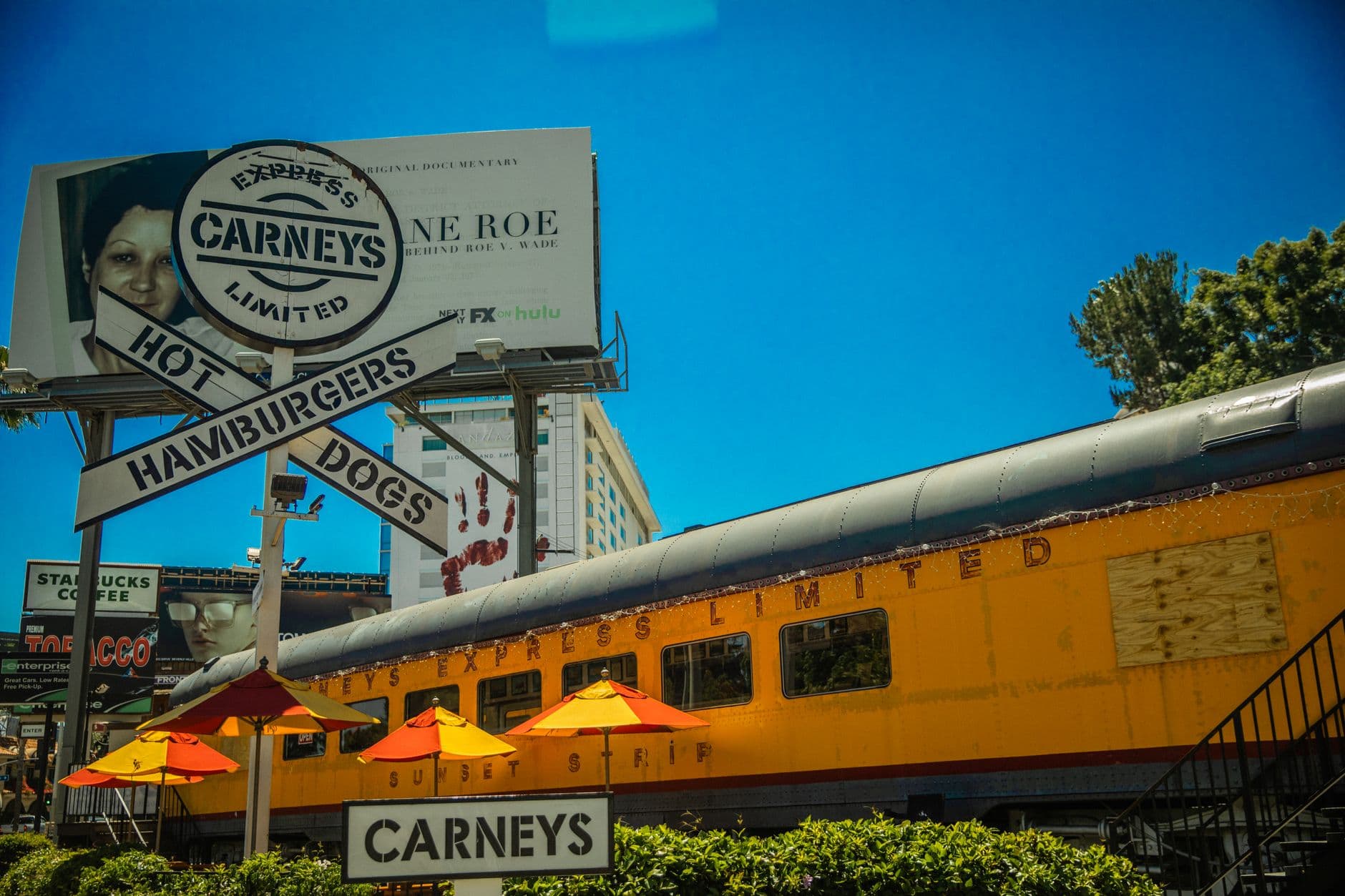 Iconic Los Angeles Carney's restaurant featuring train car dining and bold signage.