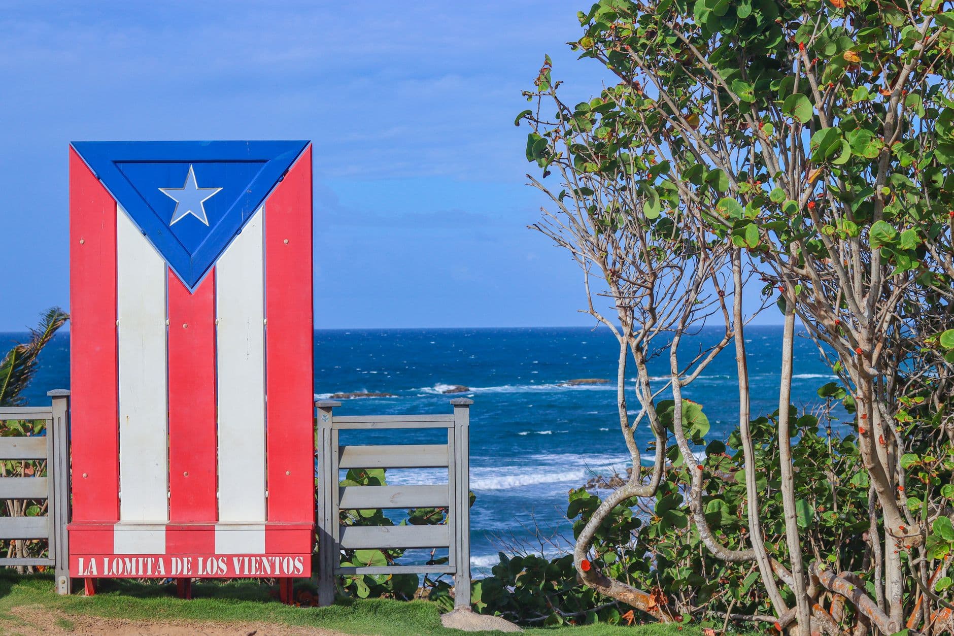 Colorful Puerto Rican flag mural at La Lomita de los Vientos with ocean view.