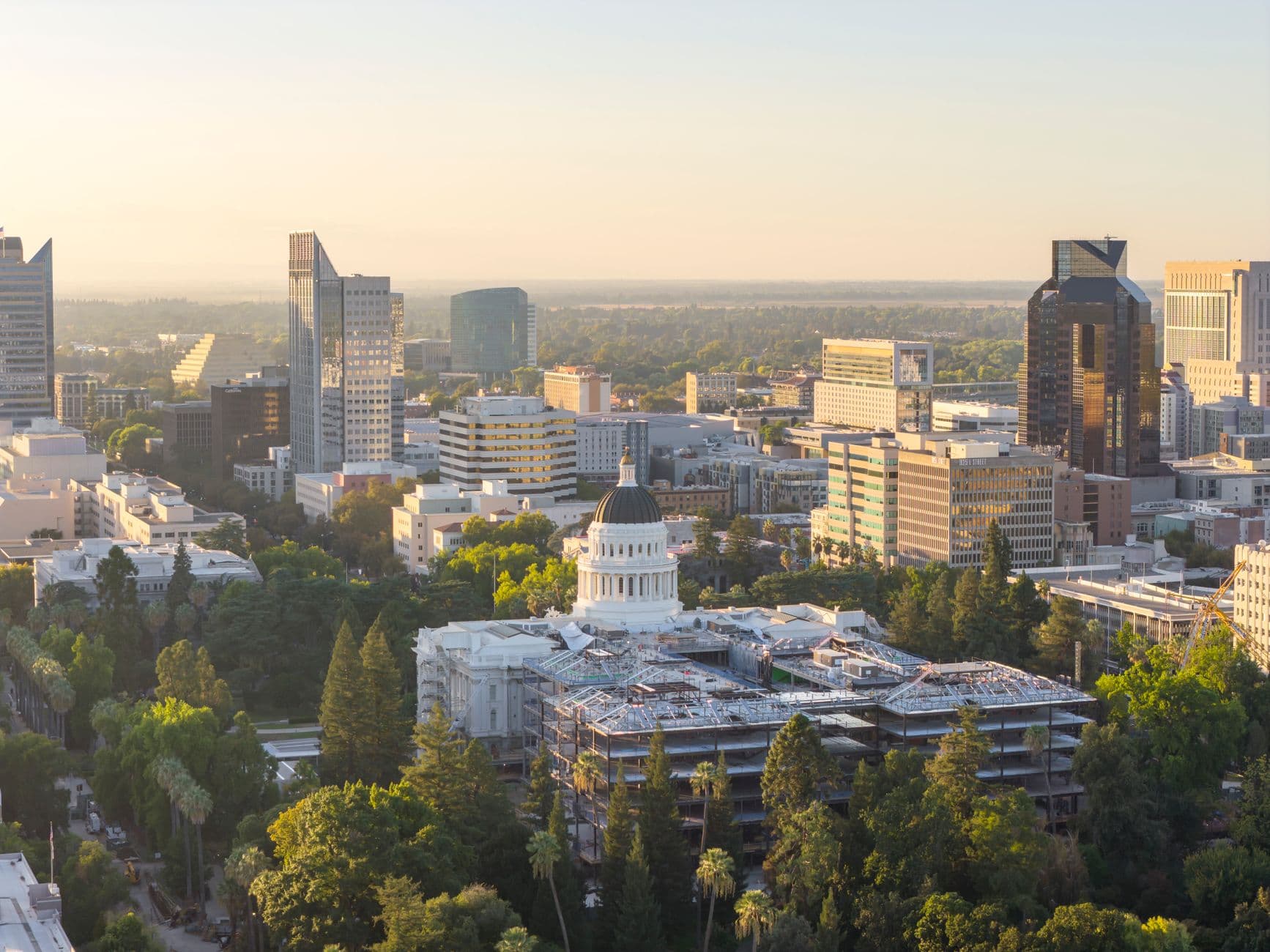 Aerial view of Sacramento cityscape featuring the California State Capitol at sunset.