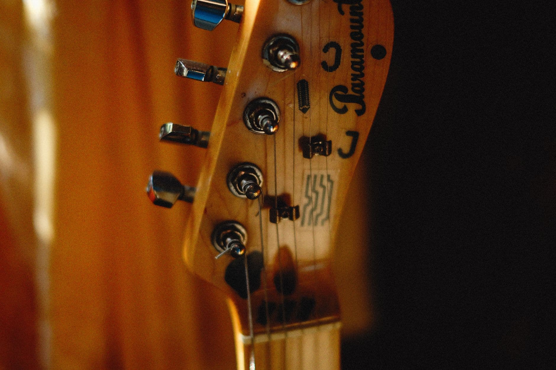 Detailed close-up of a guitar headstock showcasing strings and tuning pegs.
